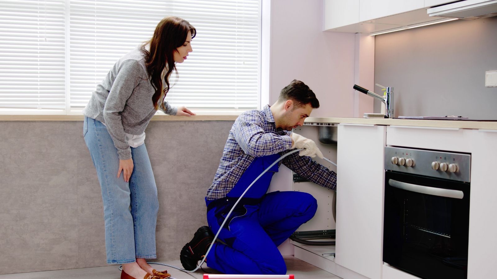Sydney plumber clearing a blocked kitchen sink